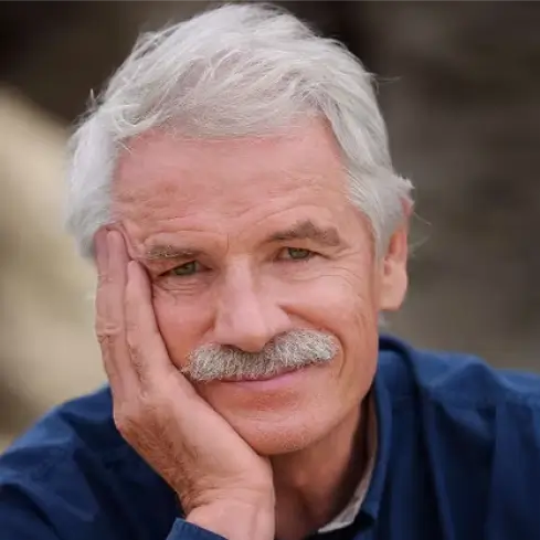 Portrait de Yann Arthus-Bertrand, photographe et fondateur de l'association de la Vallée de la Millière, engagé pour le réensauvagement, la protection de la biodiversité et la restauration des zones humides.